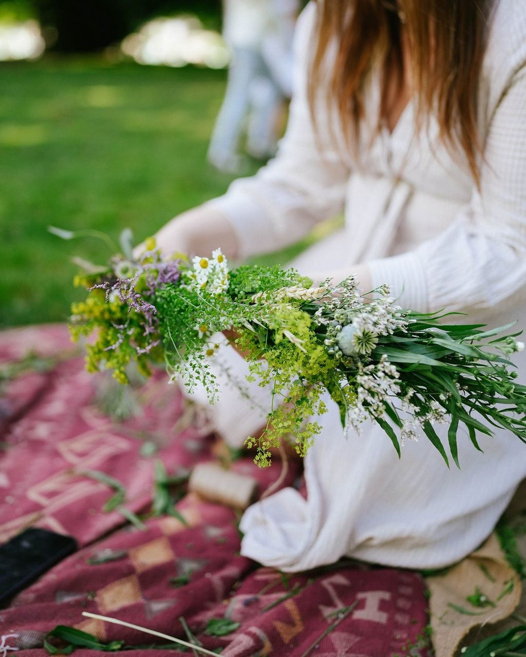Wedding rings and a hand-tied bouquet on a green velvet box